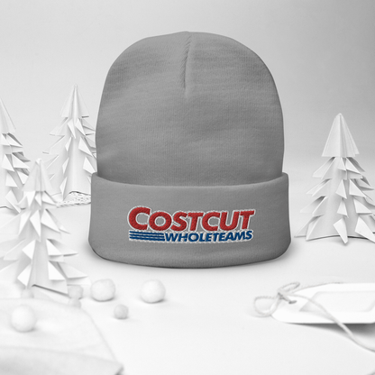 A grey/gray beanie with red and blue text "Cost cut whole teams" embroidered in the style of the "Costco Wholesale" logo, on a festive winter background surrounded by pine trees