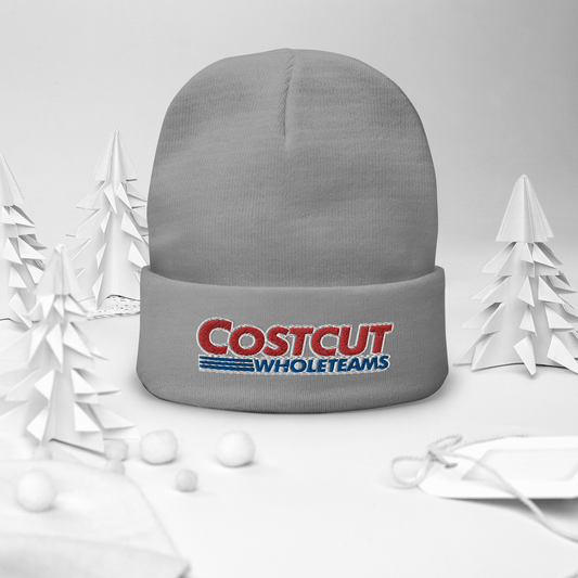 A grey/gray beanie with red and blue text "Cost cut whole teams" embroidered in the style of the "Costco Wholesale" logo, on a festive winter background surrounded by pine trees